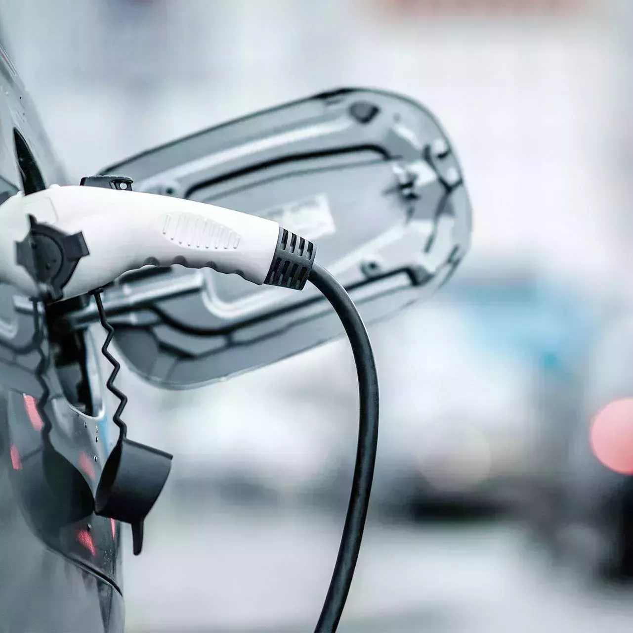 Öppna laddningsluckan på elbilen med laddningslock