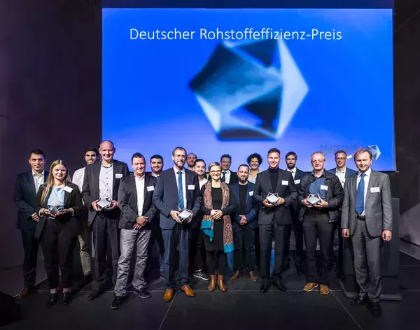 Grupp av personer med råvarueffektivitetspriset i sina händer