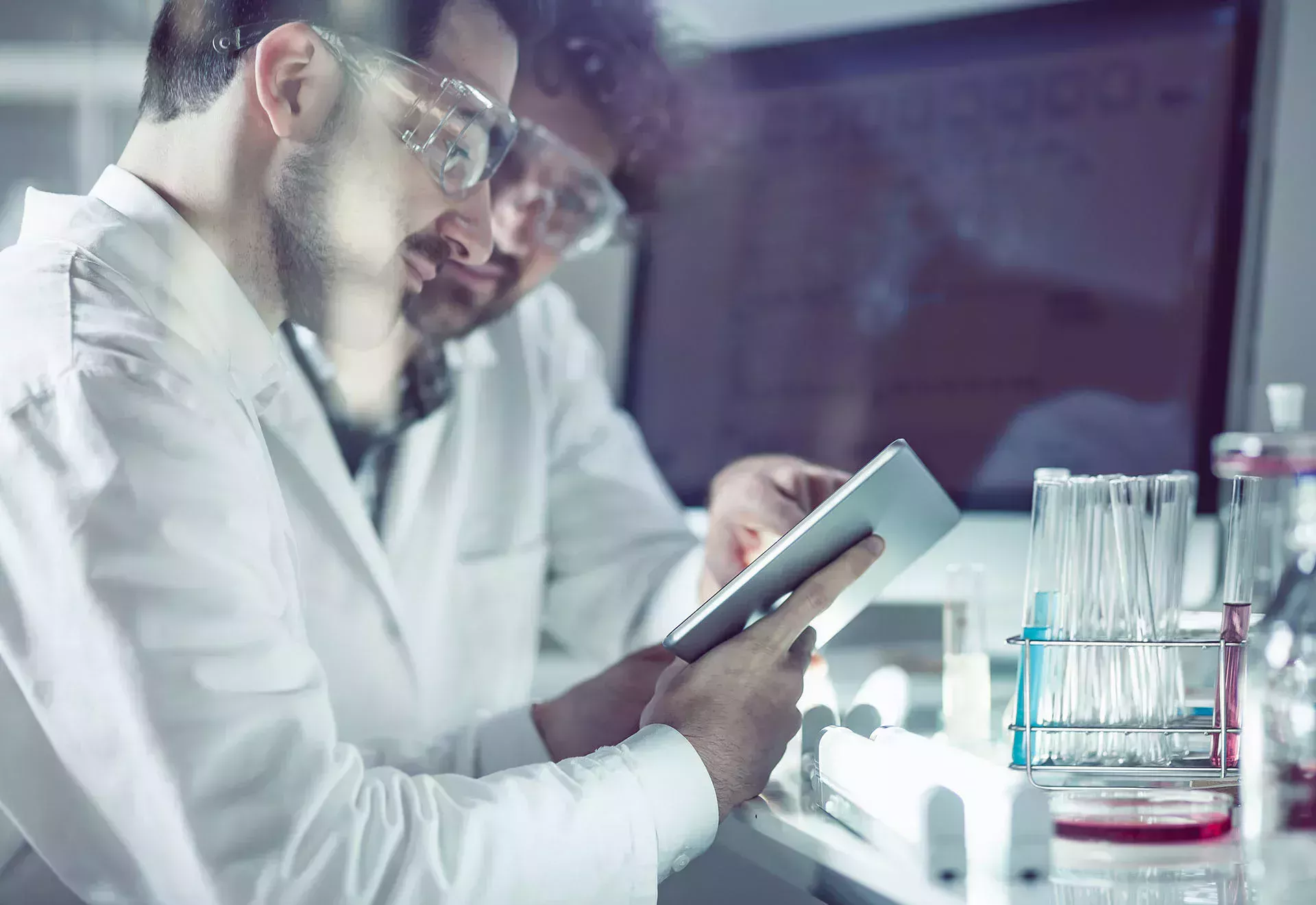 Två kemitekniker är i labbet och tittar på en surfplatta