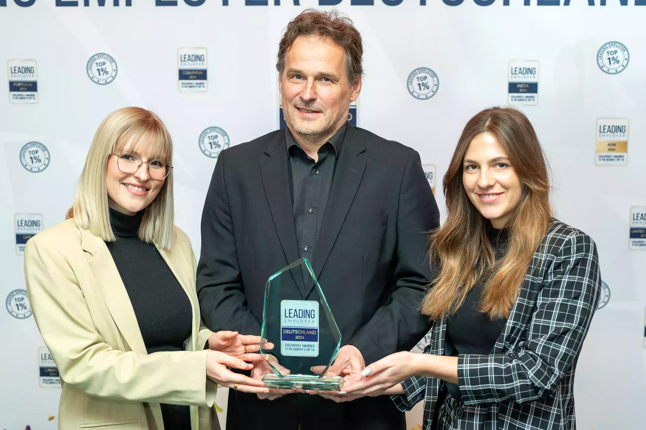 Tre medarbetare på BECHEM håller priset Leading Employer Award i sina händer