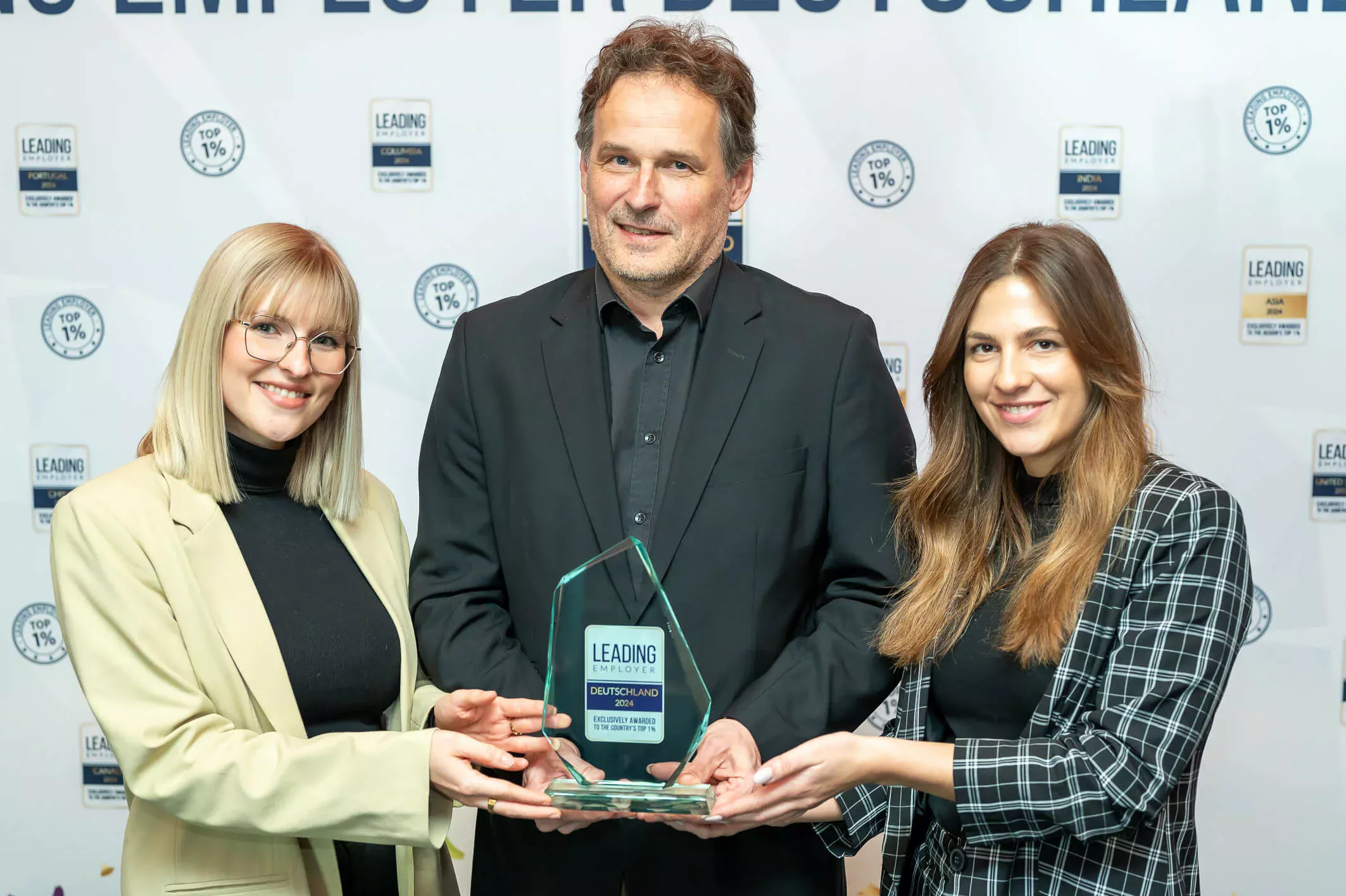 Tre medarbetare på BECHEM håller priset Leading Employer Award i sina händer